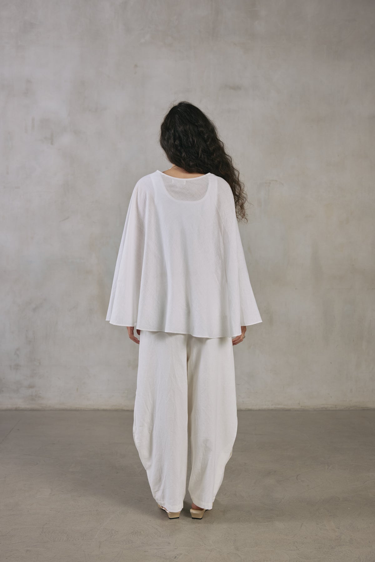 Back view of the ecru cape poncho, showing how it falls across the shoulders